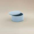 Load image into Gallery viewer, (ice)
Ice-blue round ceramic box urn by Ahava Memorials, handcrafted with ashes and shown open to reveal memorial interior.