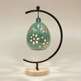 Load image into Gallery viewer, (copper)
Back of the jasper gold floral luminary by Ahava Memorials, handcrafted with ashes and illuminated by candlelight on its ceramic stand as a radiant remembrance piece.
