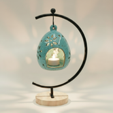 (copper)
Jasper gold ceramic floral luminary made with ashes, a luminous handcrafted cremation memorial by Ahava Memorials with a candle glowing through floral openings.