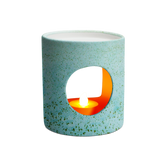 (copper)
A ceramic diffuser with a green tint and a radiant glow, designed to hold a votive candle.