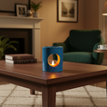Load image into Gallery viewer, Blue candle holder with a lit candle on a wooden coffee table in a cozy living room.
