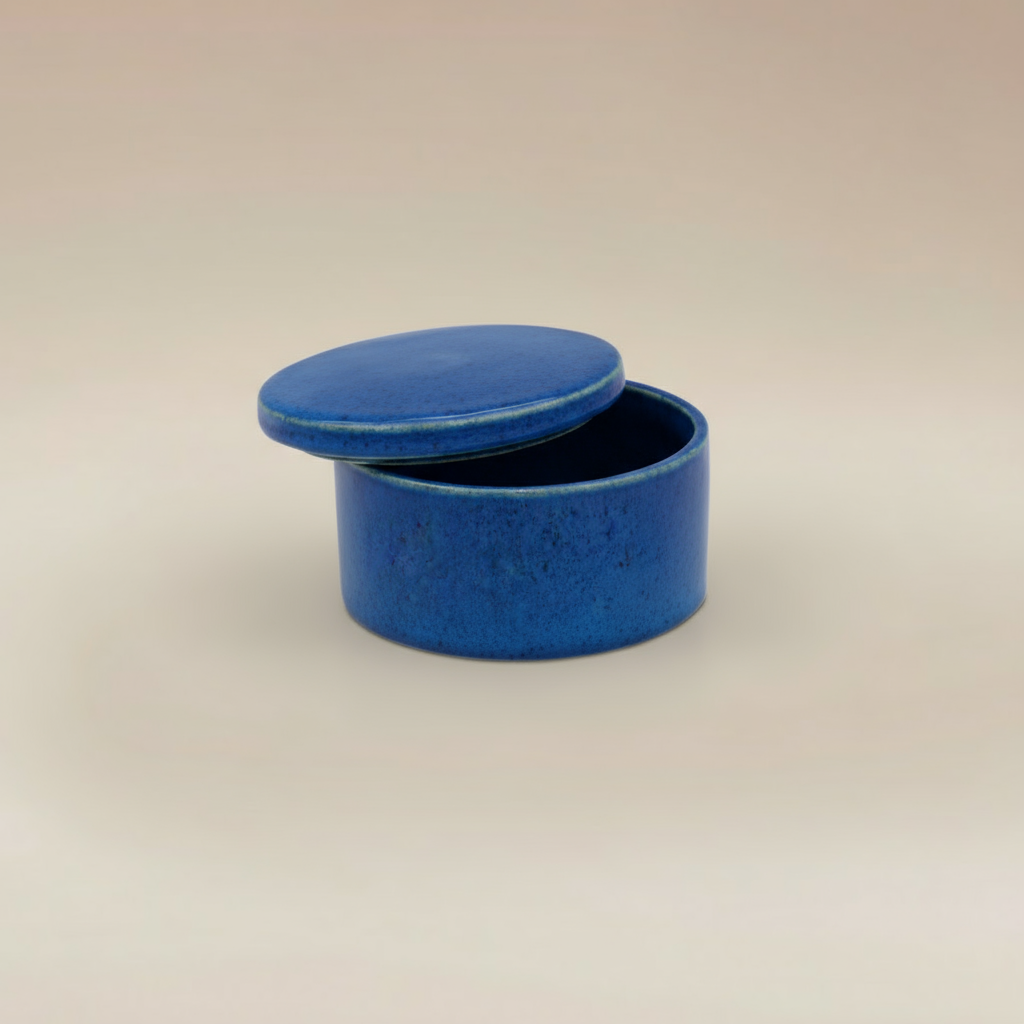 (agate blue)
Ahava Memorials agate blue round ceramic box urn, handcrafted with ashes and displayed open as a unique memorial art piece.