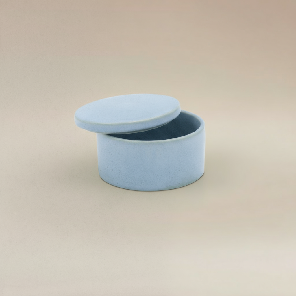 (ice)
Ice-blue round ceramic box urn by Ahava Memorials, handcrafted with ashes and shown open to reveal memorial interior.