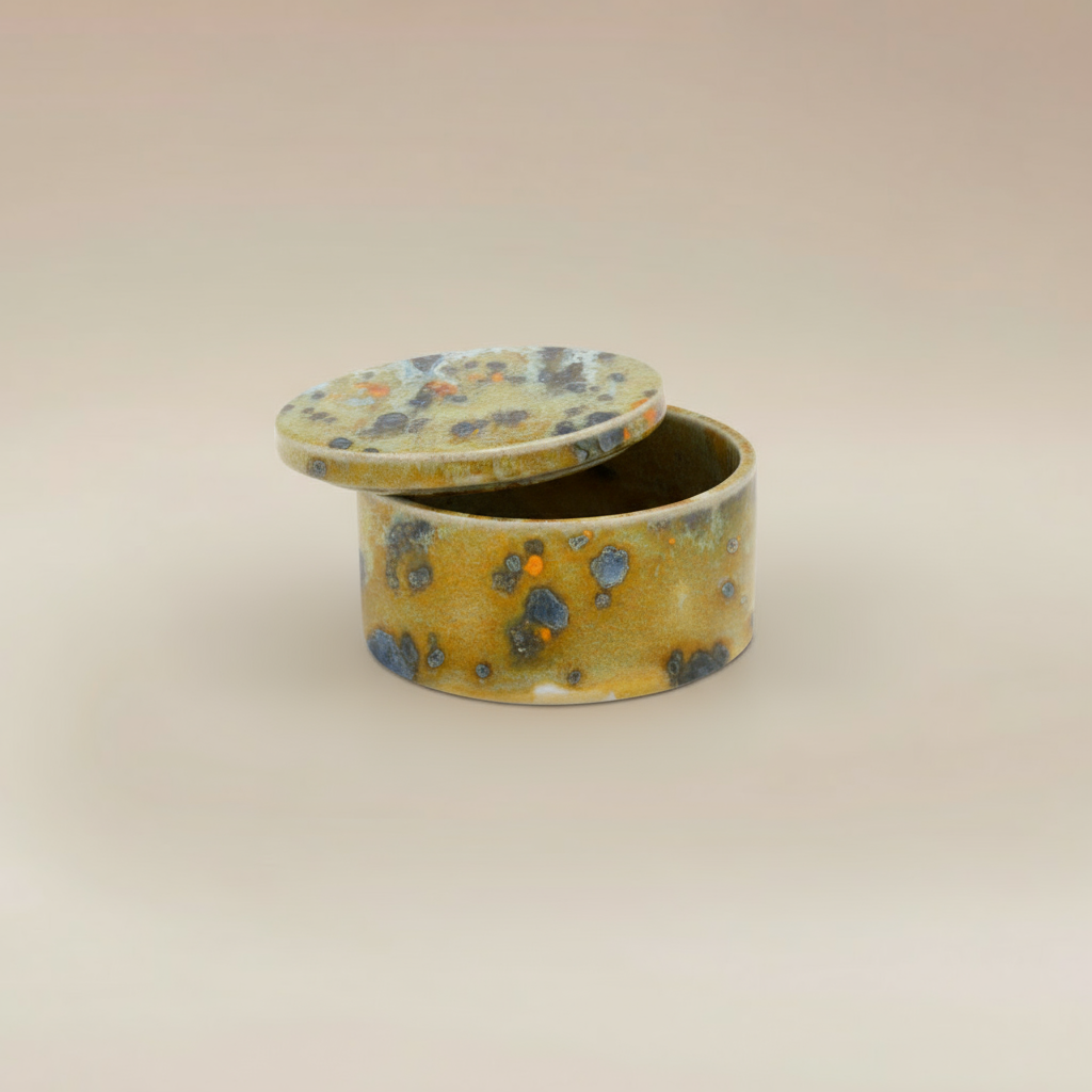 (jasper gold)
Ahava Memorials jasper gold round ceramic box urn handcrafted with ashes, shown open as a radiant memorial keepsake.